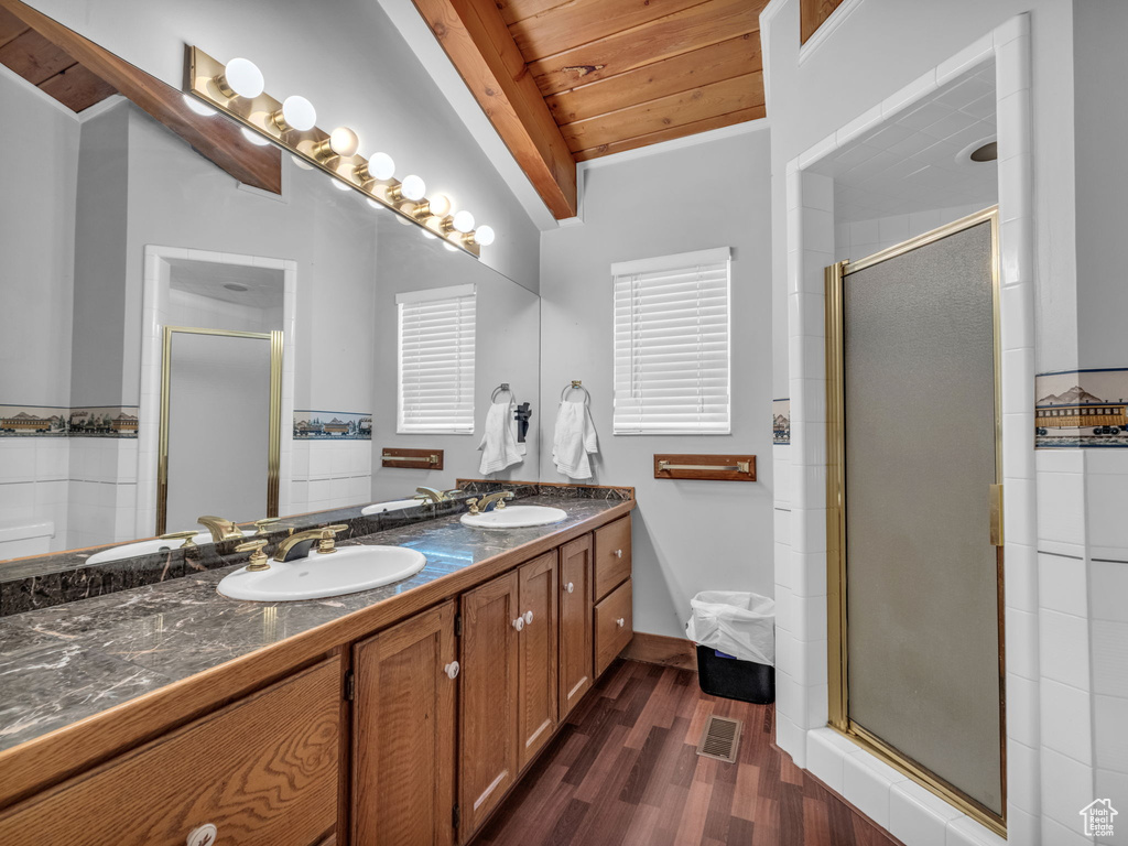 Full bathroom featuring wood ceiling, wood finished floors, double vanity, a shower stall, and lofted ceiling