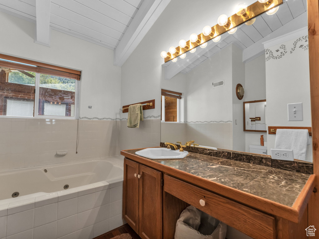 Full bath with wood ceiling, a jetted tub, and vanity
