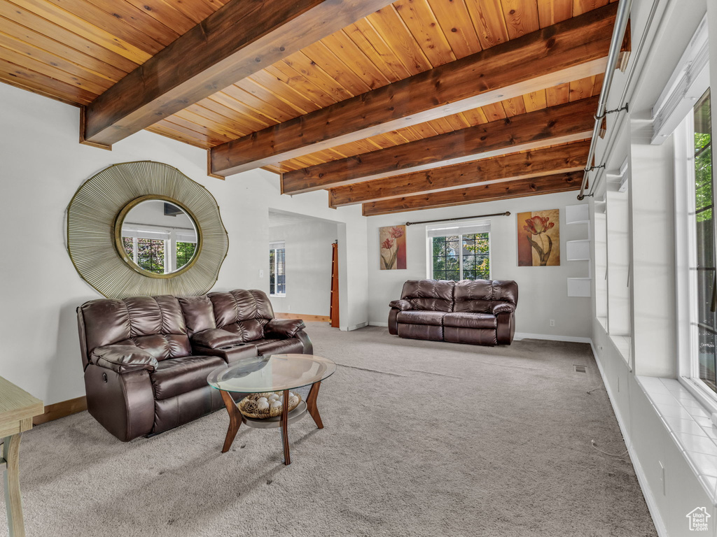 Carpeted living room featuring a wood ceiling with exposed beams and baseboards