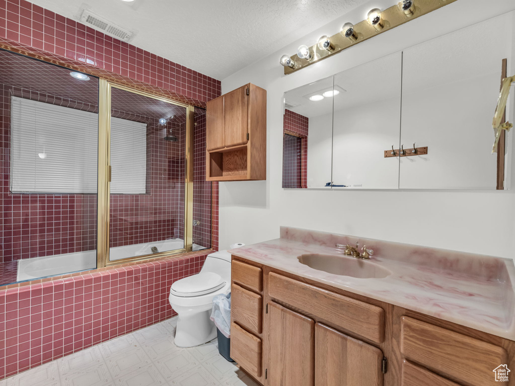 Bathroom featuring tiled shower / bath, vanity, and tile patterned floors