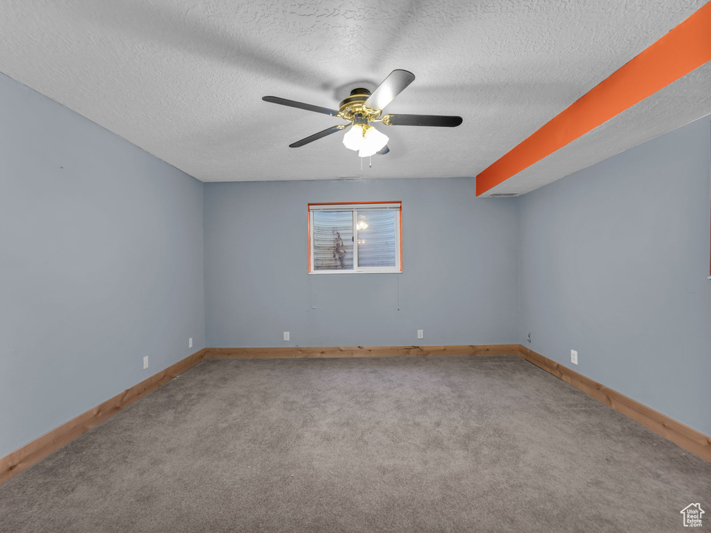 Unfurnished room with a ceiling fan, carpet, and a textured ceiling