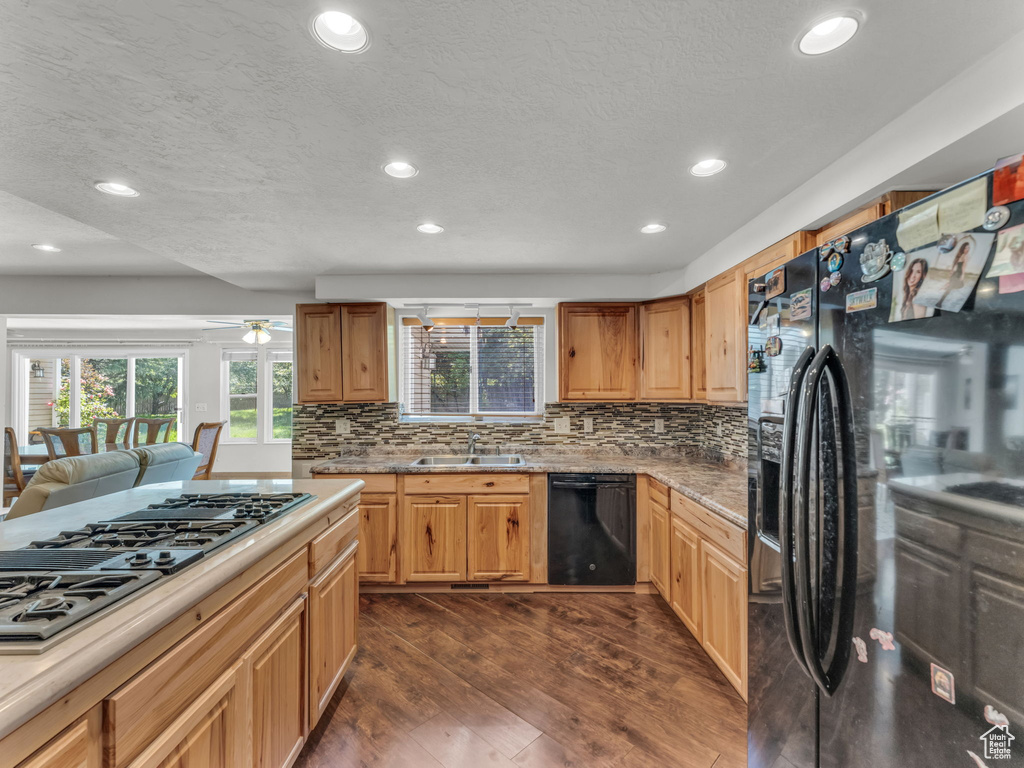 Kitchen with black appliances, recessed lighting, plenty of natural light, dark wood-type flooring, and backsplash