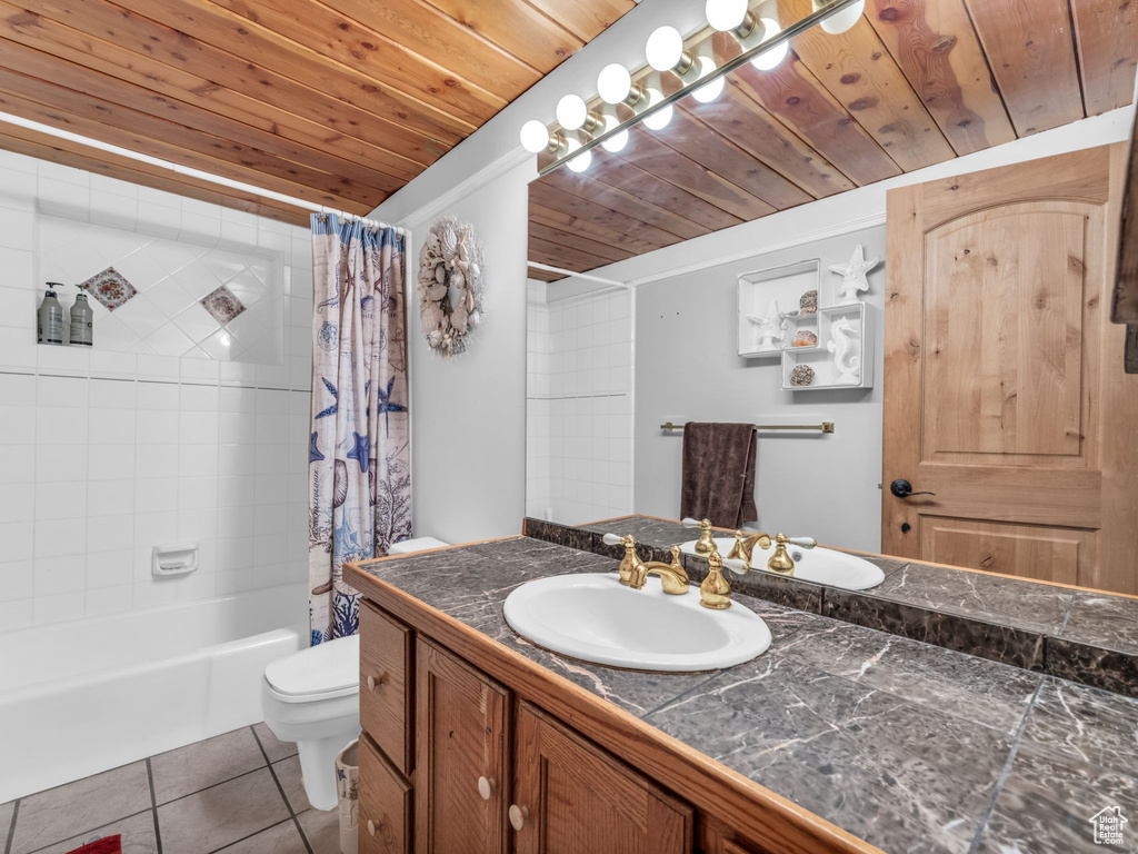 Bathroom with wooden ceiling, vanity, tile patterned floors, and shower / bathtub combination with curtain