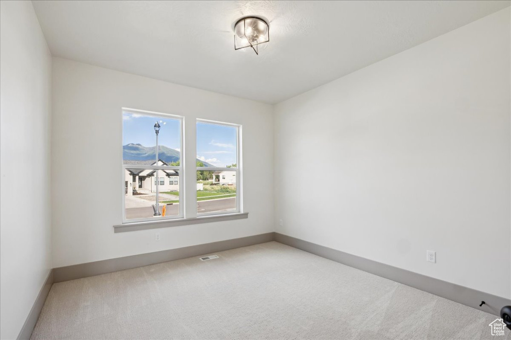Carpeted empty room featuring baseboards