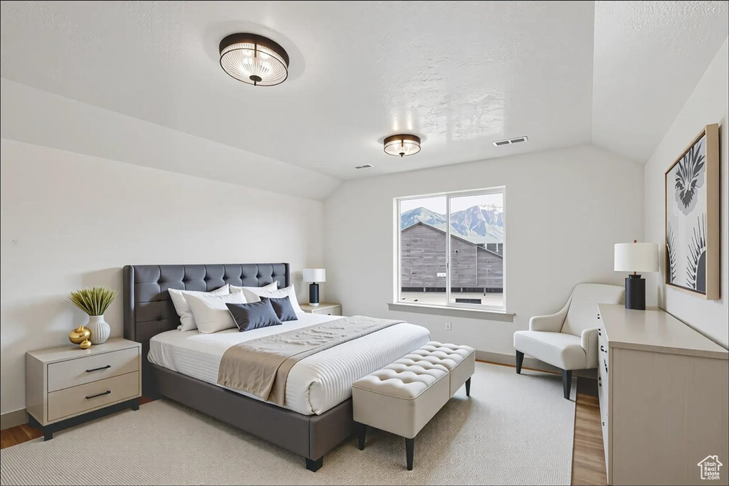 Bedroom with lofted ceiling and light wood-style floors