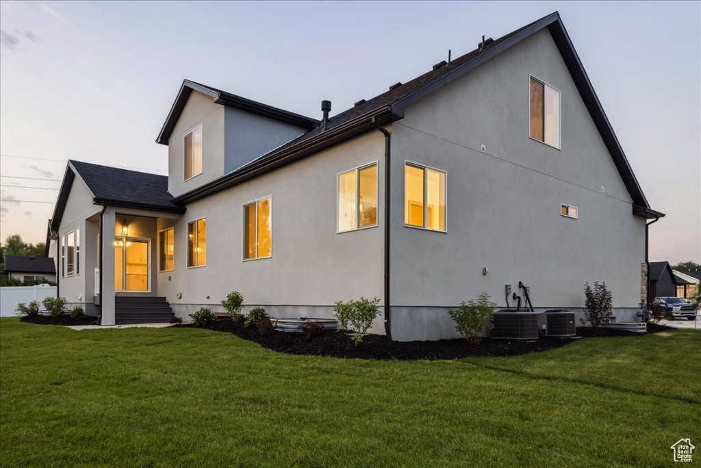 Rear view of property with a yard and stucco siding