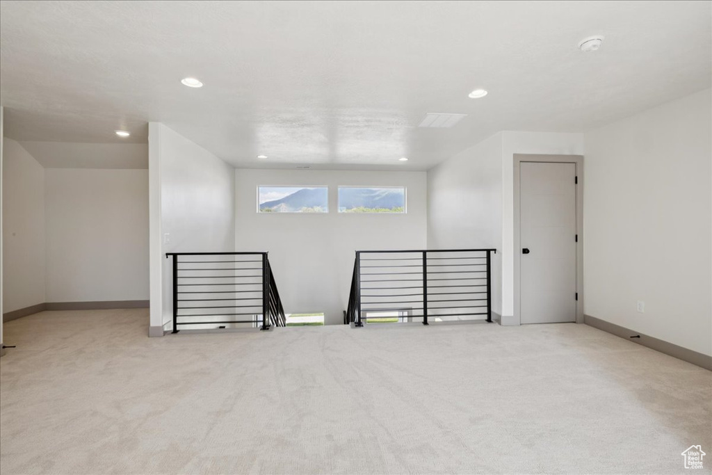 Empty room with carpet flooring, a smoke detector, and recessed lighting