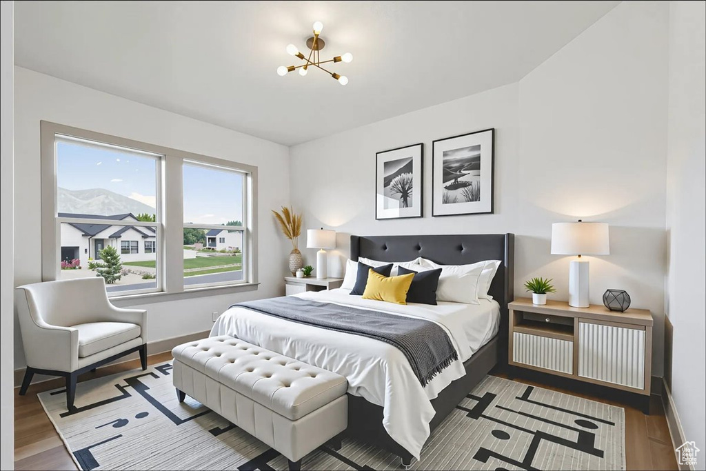Bedroom featuring a chandelier and wood finished floors