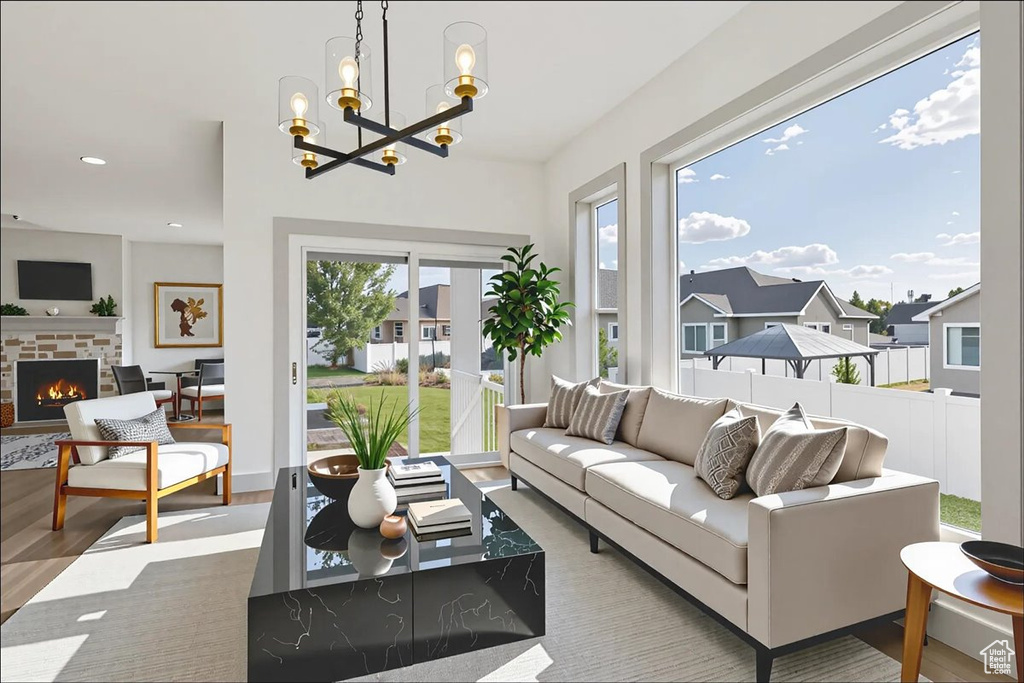 Living area featuring a brick fireplace, a chandelier, recessed lighting, and wood finished floors
