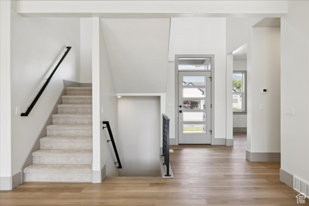 Stairs featuring wood finished floors