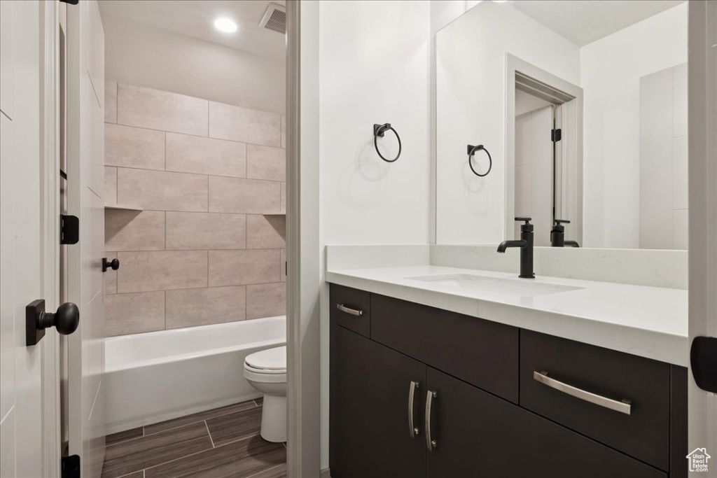 Bathroom featuring vanity, washtub / shower combination, and wood tiled floors