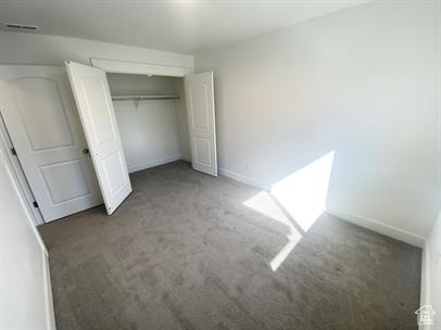 Unfurnished bedroom featuring light carpet and a closet