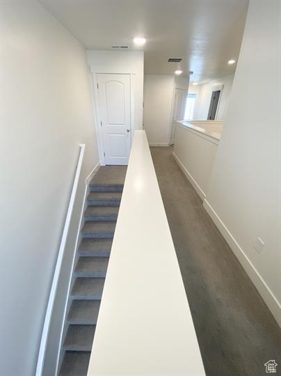 Staircase with carpet and recessed lighting