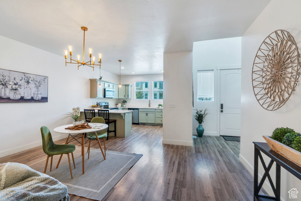 Dining area featuring a chandelier and dark wood-style flooring