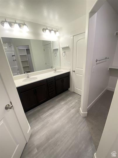 Bathroom with double vanity and wood finished floors