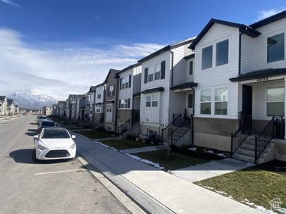 View of asphalt street featuring sidewalks, curbs, and a residential view