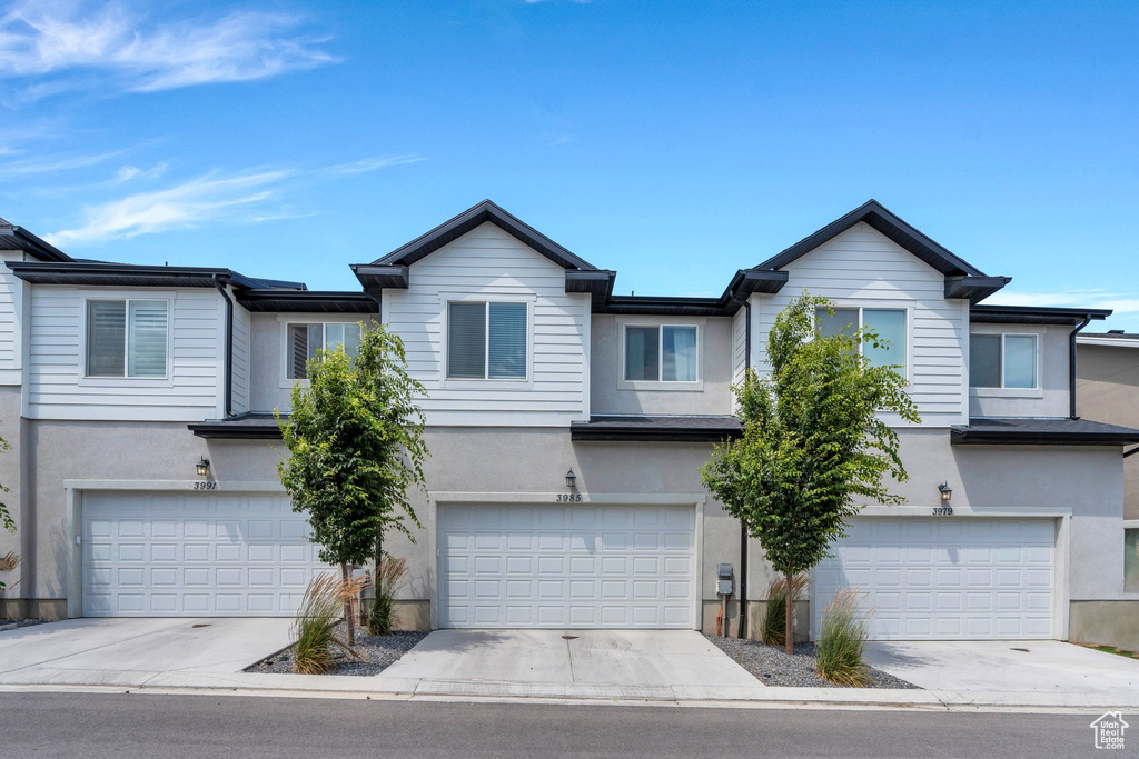 View of front facade with stucco siding and an attached garage