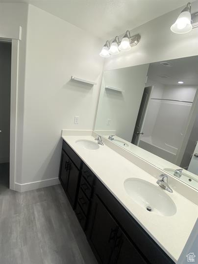 Bathroom featuring double vanity and wood finished floors
