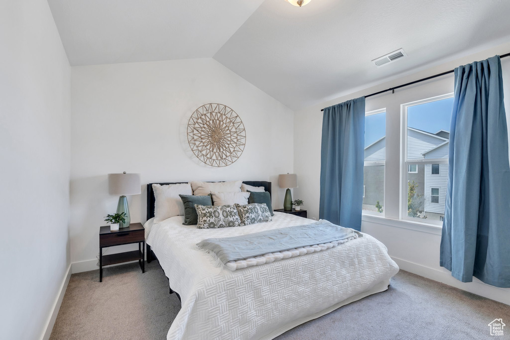 Bedroom featuring carpet floors, multiple windows, and vaulted ceiling