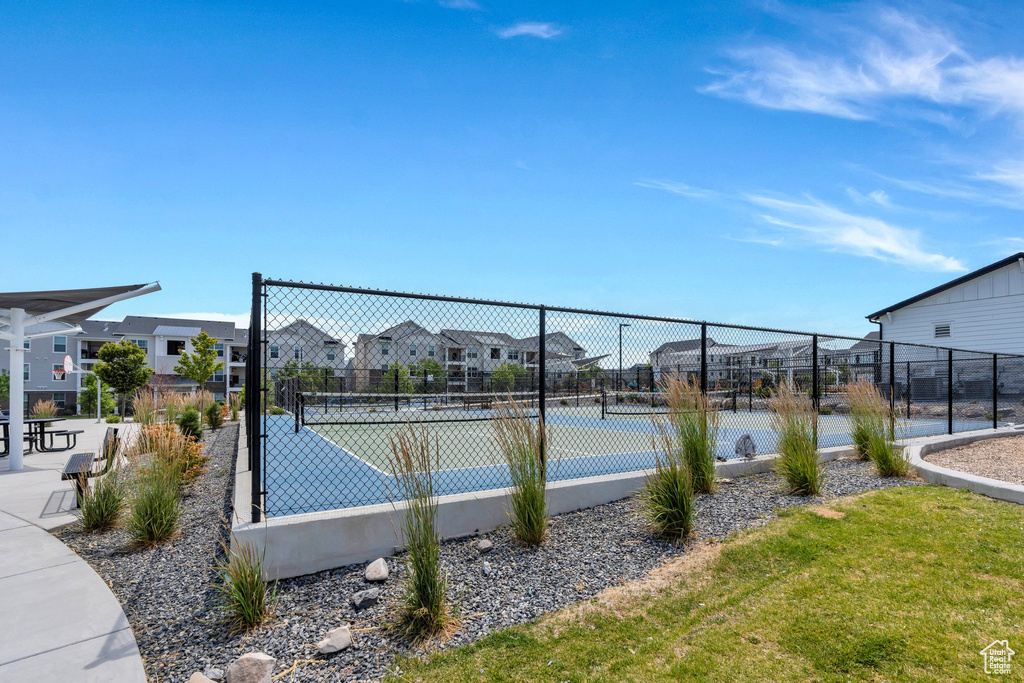 View of tennis court with a residential view
