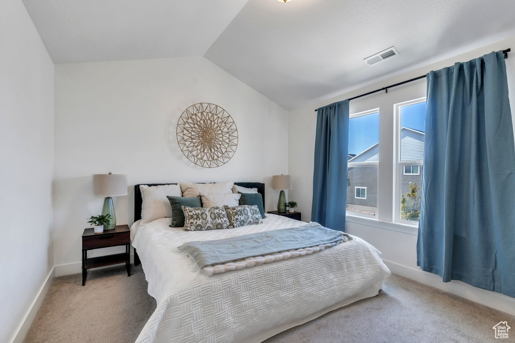 Carpeted bedroom featuring vaulted ceiling and baseboards