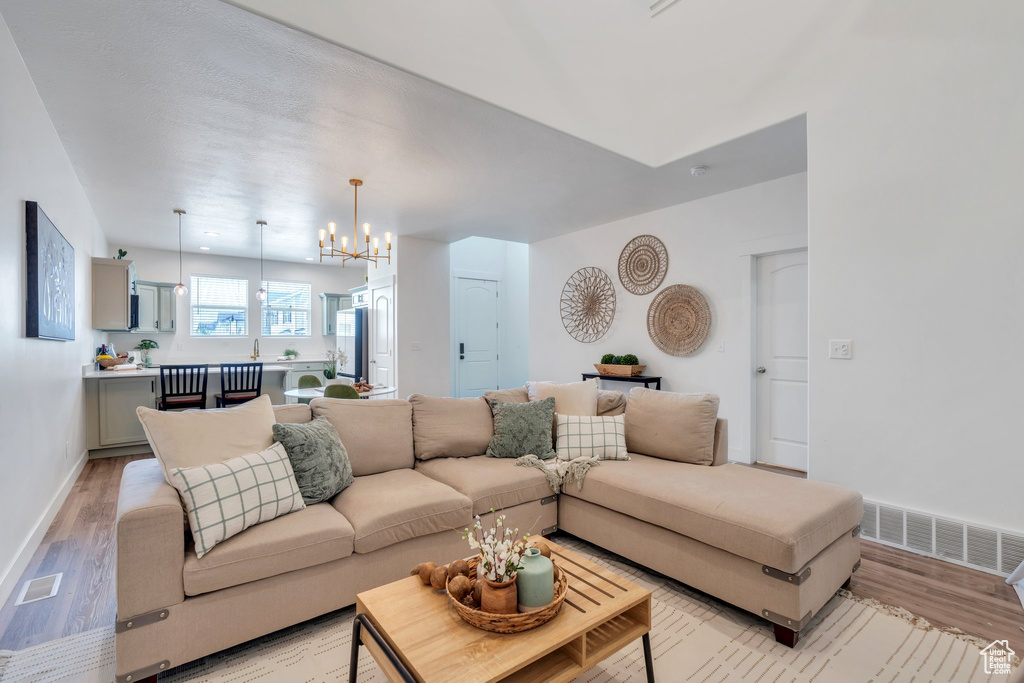 Living room with a chandelier and light wood-style flooring