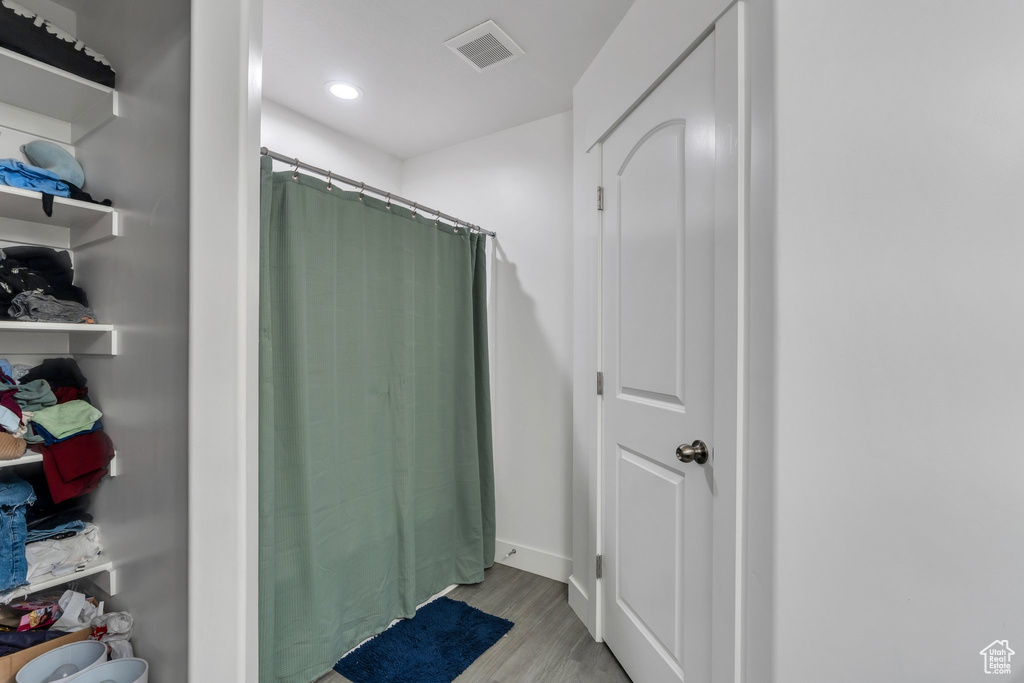 Full bath featuring wood finished floors, curtained shower, and recessed lighting