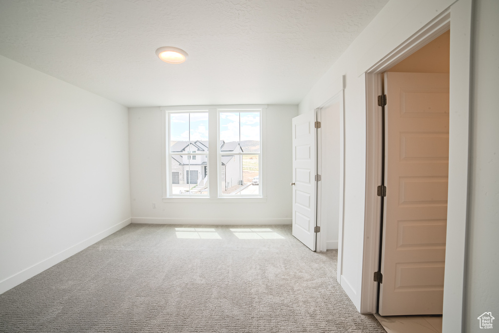 Unfurnished room featuring light colored carpet
