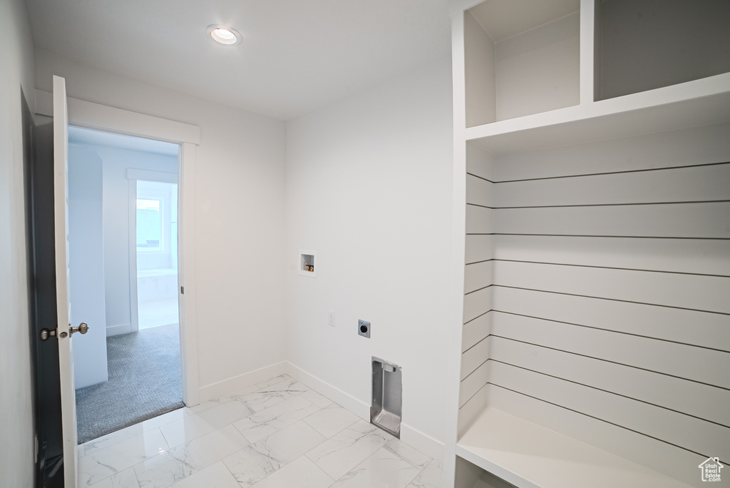 Laundry room with electric dryer hookup, light marble finish flooring, recessed lighting, and hookup for a washing machine