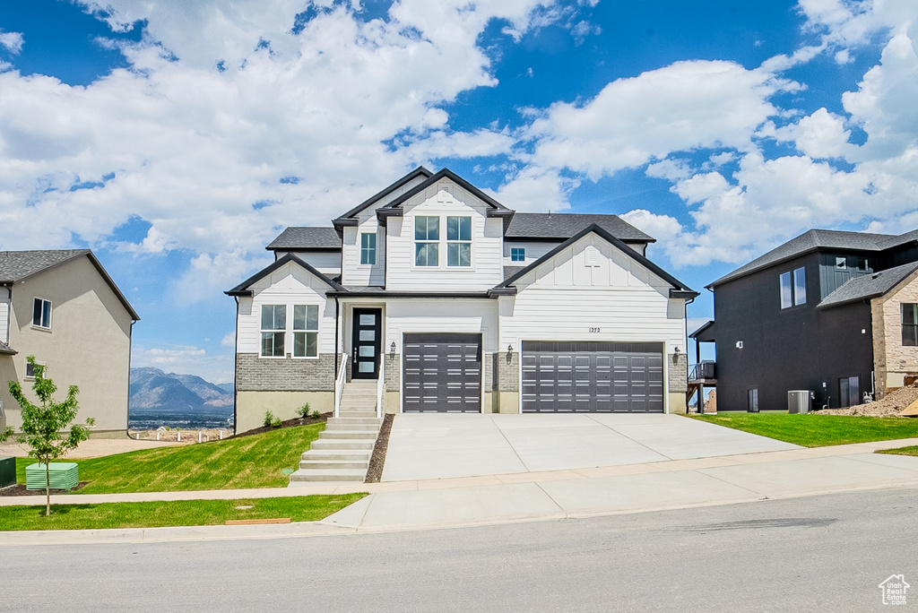 View of front of house featuring an attached garage, driveway, and board and batten siding