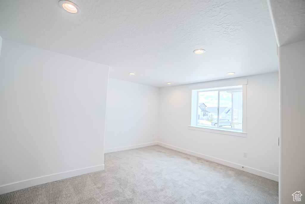 Spare room with light colored carpet, recessed lighting, and a textured ceiling