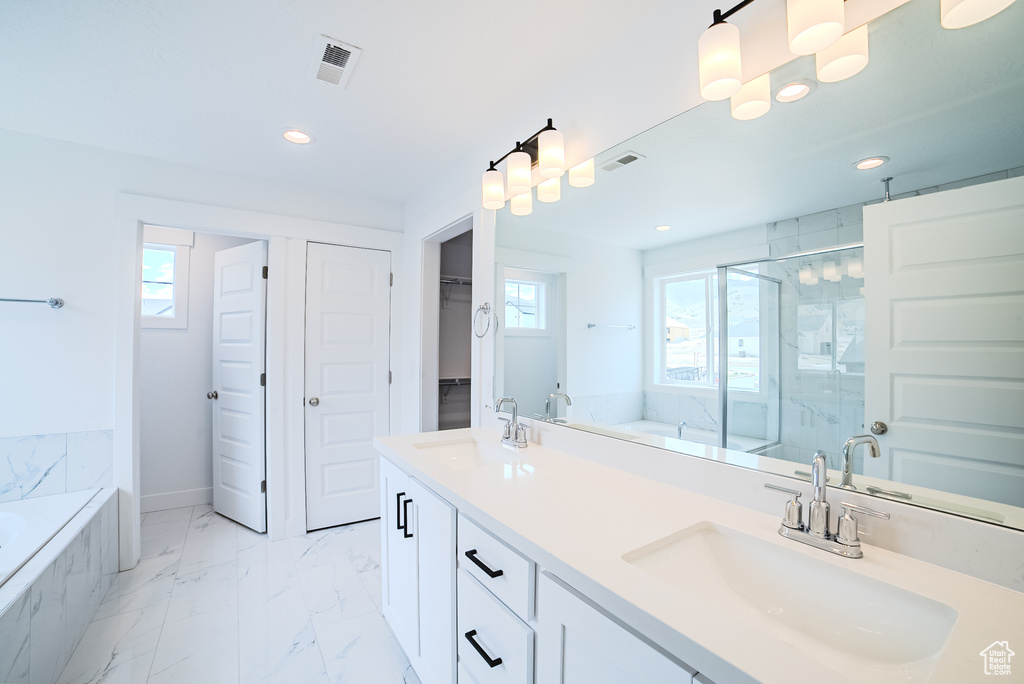 Bathroom featuring a marble finish shower, a bath, recessed lighting, marble finish floors, and double vanity