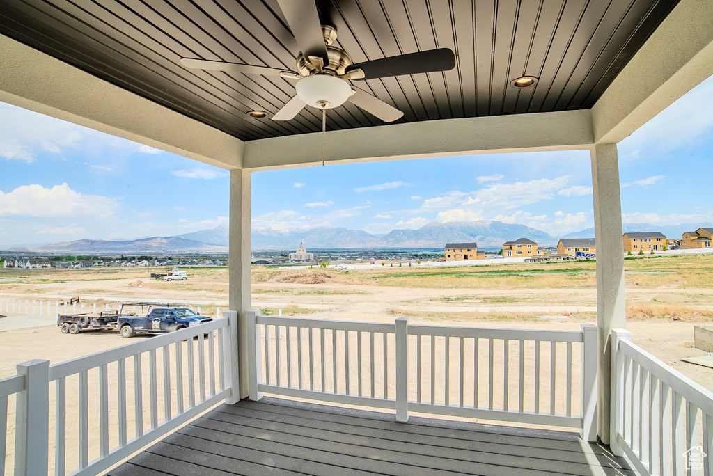 Wooden terrace featuring a mountain view and a ceiling fan