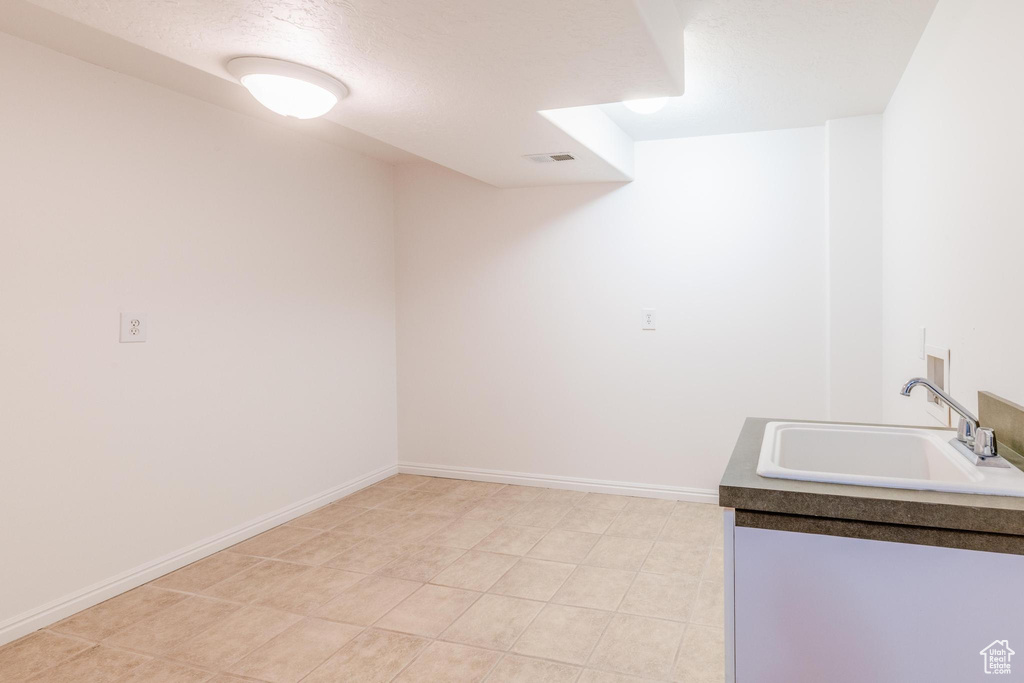 Laundry room featuring a sink and baseboards