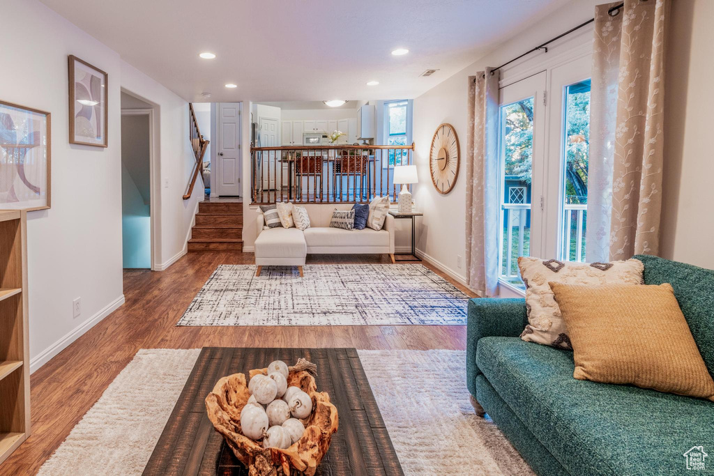 Living area with stairway, wood finished floors, and recessed lighting