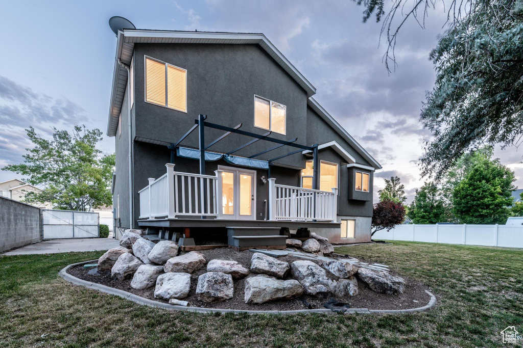 Rear view of property with a deck and stucco siding