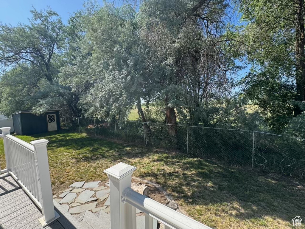 Fenced yard featuring a storage unit