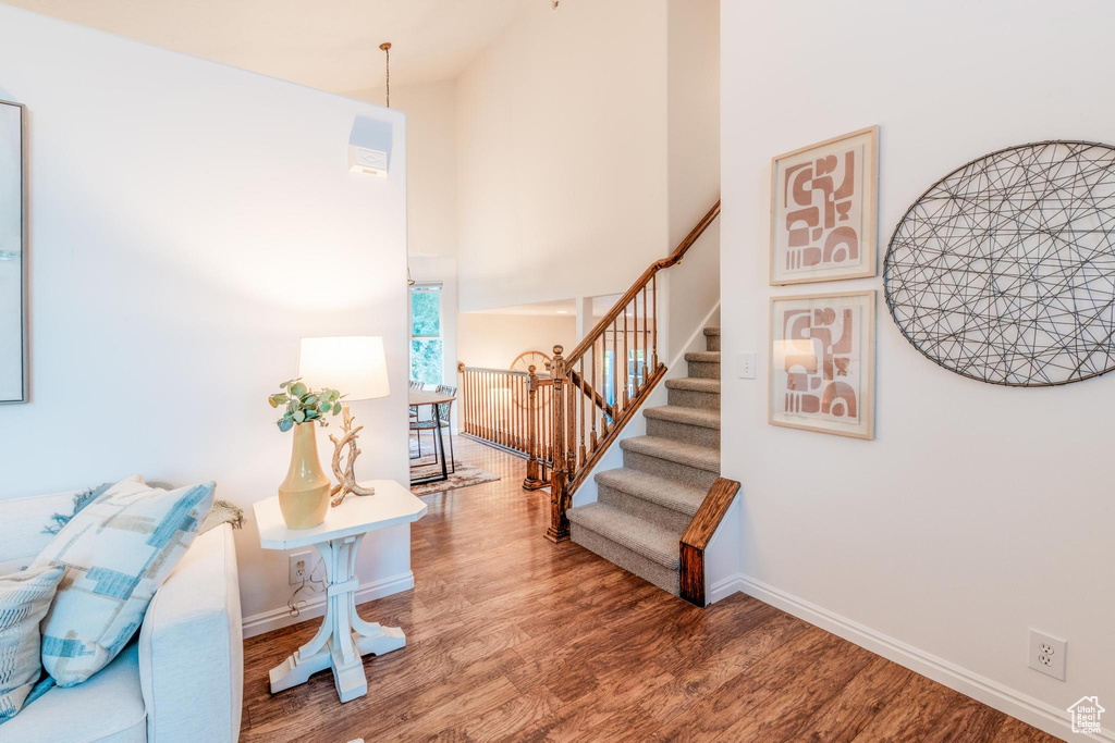 Staircase with a high ceiling and wood finished floors