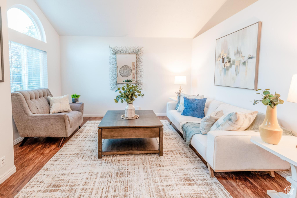 Living area with vaulted ceiling and wood finished floors
