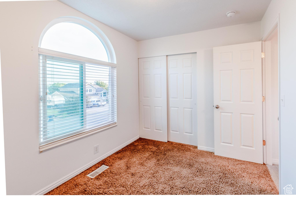 Unfurnished bedroom featuring carpet flooring and a closet