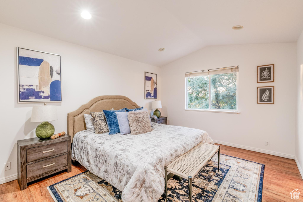 Bedroom featuring light wood finished floors, vaulted ceiling, and recessed lighting