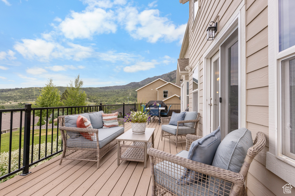 Wooden deck featuring an outdoor hangout area and a mountain view