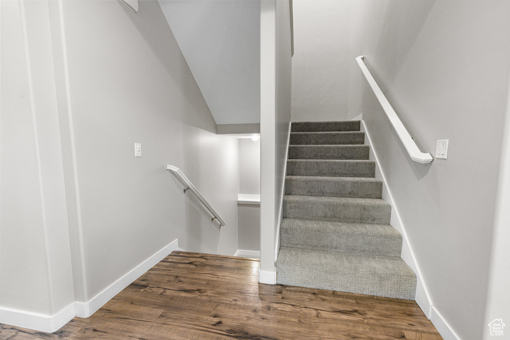 Staircase featuring baseboards and wood finished floors