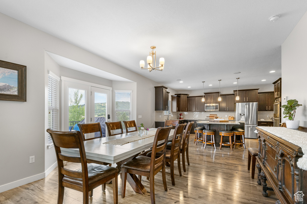 Dining space with a chandelier, light wood finished floors, and recessed lighting