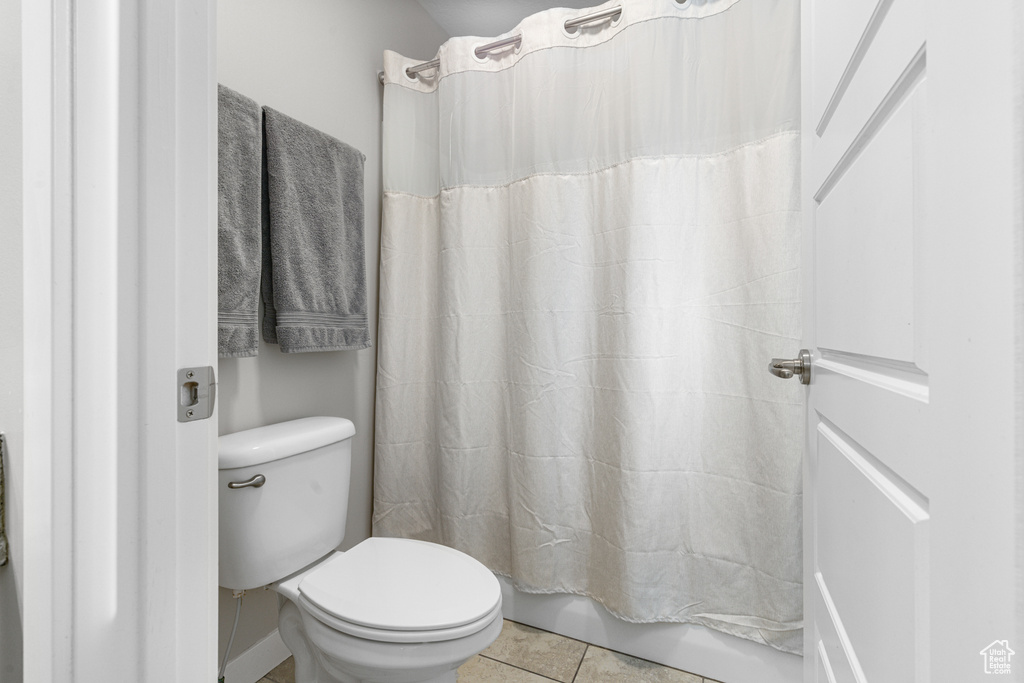 Full bath with toilet and tile patterned flooring