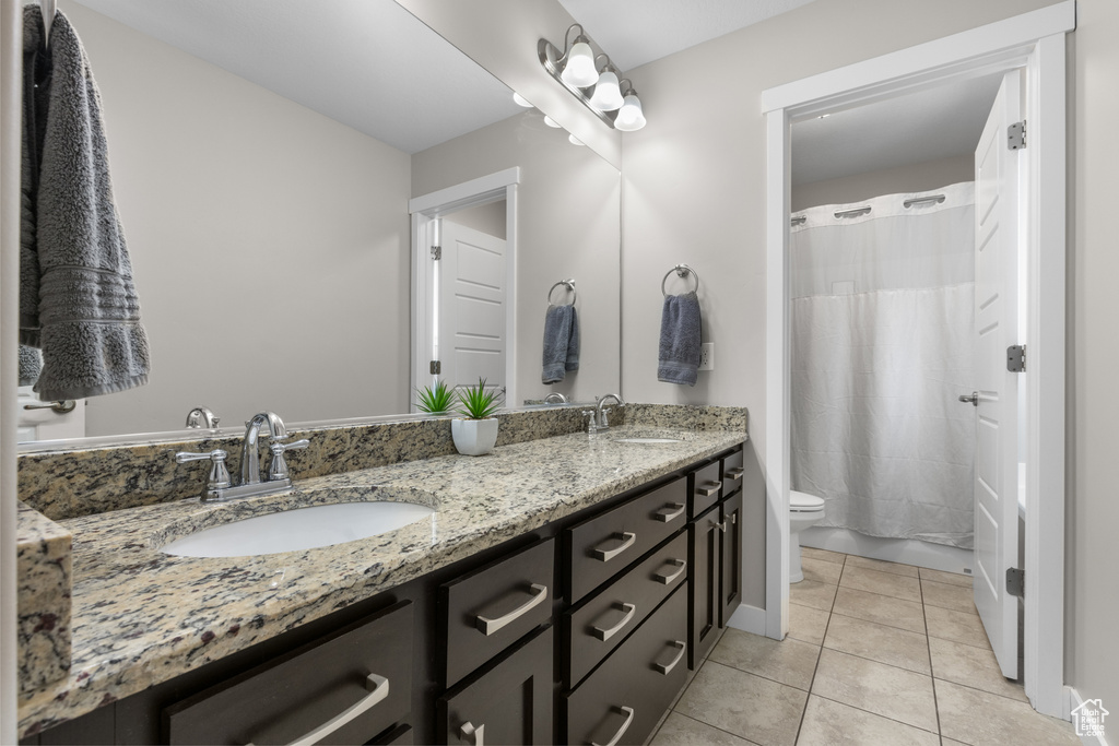 Bathroom with double vanity and tile patterned floors