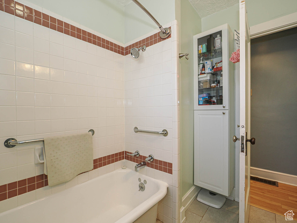 Bathroom featuring tile patterned floors and tub / shower combination