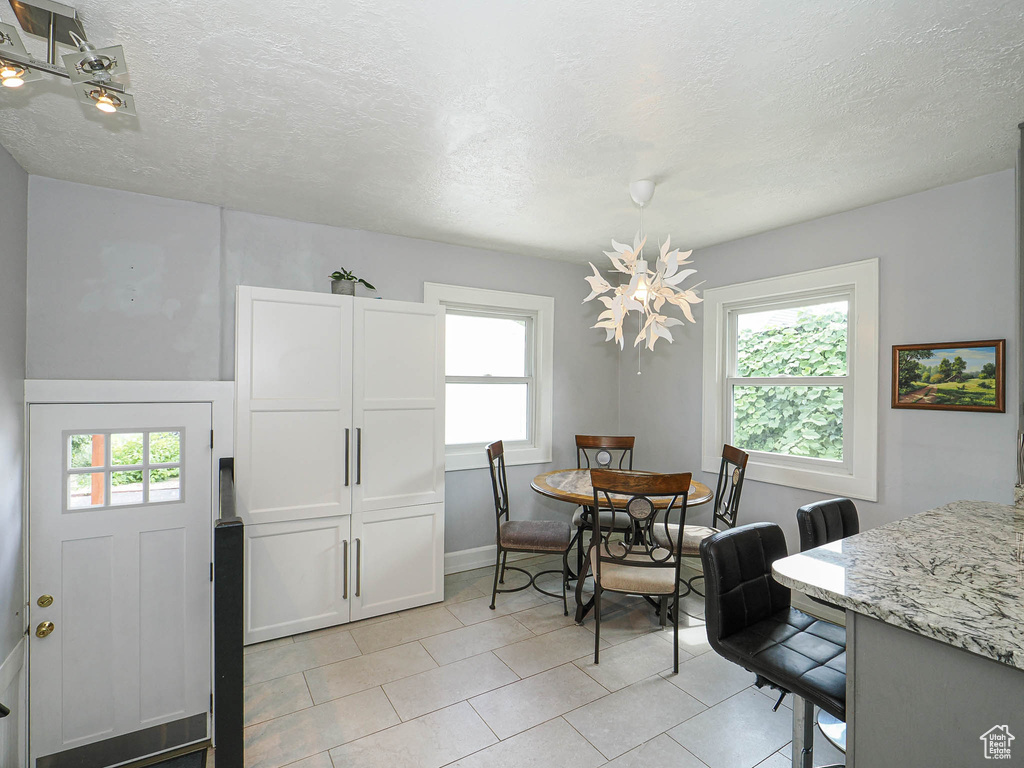 Dining space featuring light tile patterned floors and a textured ceiling
