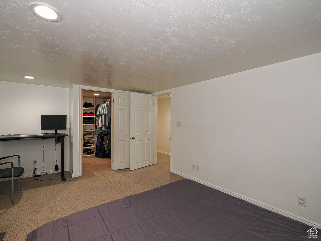 Unfurnished bedroom featuring a spacious closet, a closet, and carpet flooring