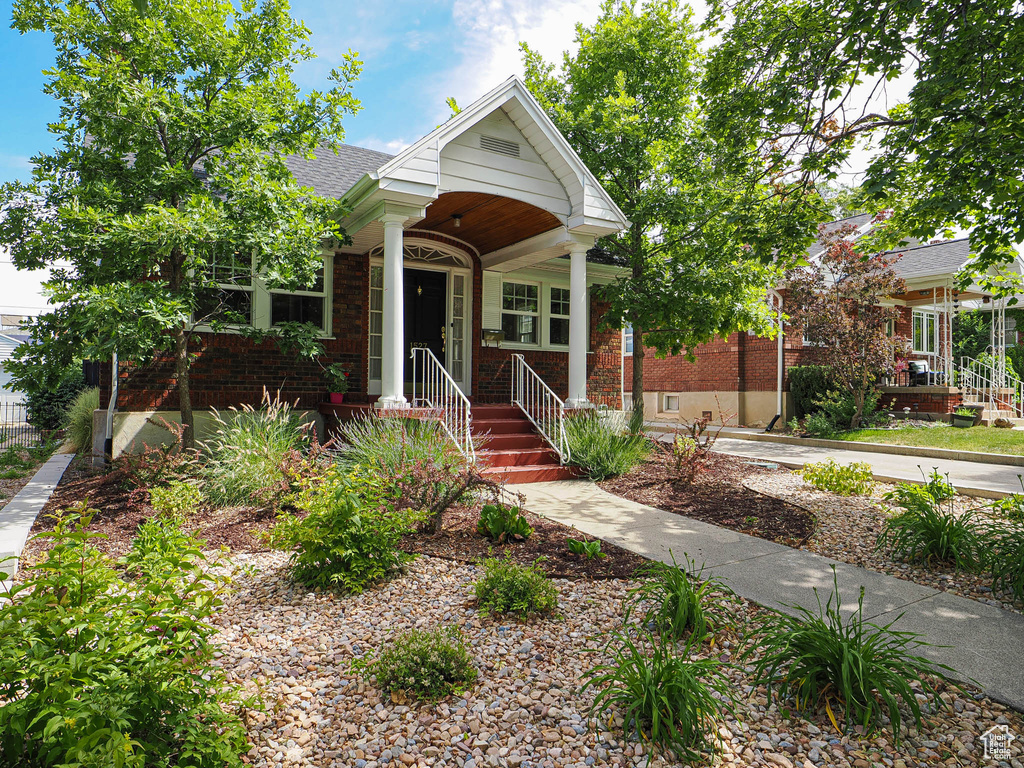 Bungalow-style house with brick siding and a shingled roof